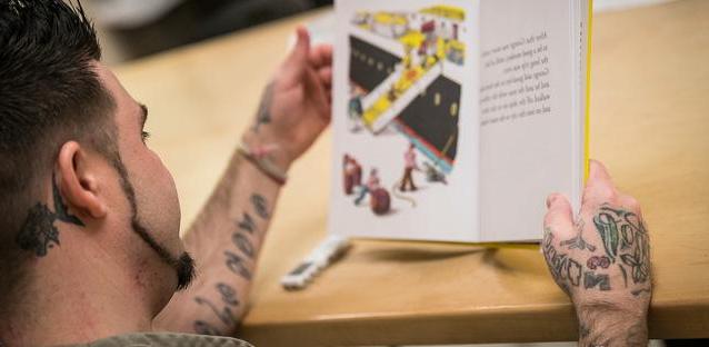 A Boulder County Jail inmate reads a children’s book as part of a study by UNC assistant professor Kyle Ward, who is researching the effects of incarceration and family bonds. 摄影:亨特·威尔逊